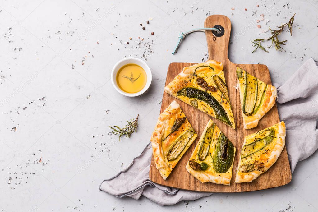 Pizza with baby zucchini on wooden board - party snack