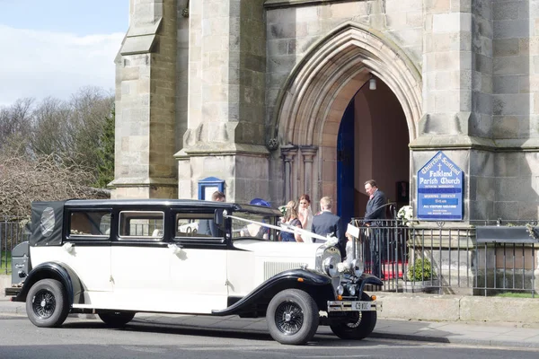 Un coche de boda clásico, novia, dama de honor en la puerta antes de cere —  Fotos de Stock