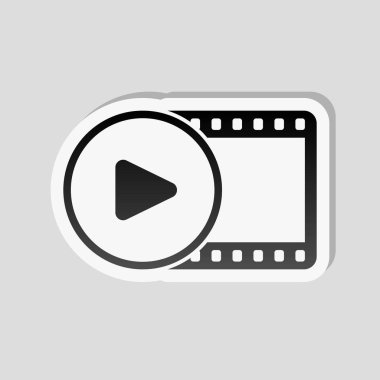 Film şeridi daire içinde oyun simgesiyle. basit siluet. Etiket tarzı ile beyaz ve gri arka plan üzerinde basit gölge