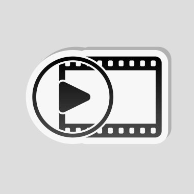 Film şeridi daire içinde oyun simgesiyle. basit siluet. Etiket tarzı ile beyaz ve gri arka plan üzerinde basit gölge