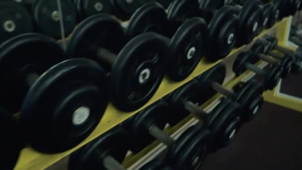 Many dumbbells on the counter in the gym. Slow motion