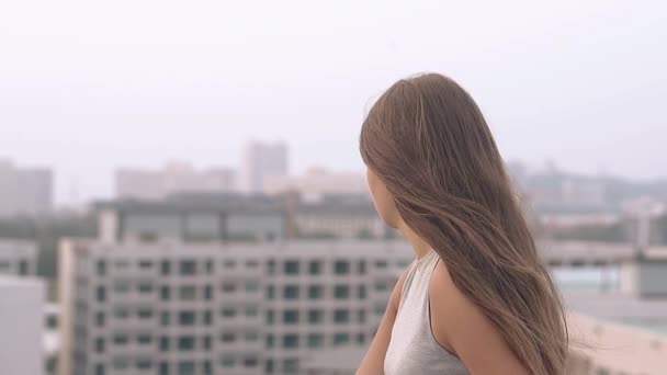 Young woman in grey wear looks at evening city slow motion — Stock Footage Young woman in grey wear looks at evening city slow motion Stock Footage