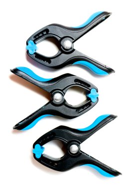 Beyaz zemin üzerinde üç plastik doğrama kelepçeler. Yukarıdan görüntüleyin. İzole