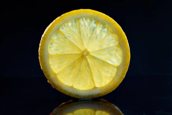 Rebanada de limón transparente sobre un fondo oscuro . — Foto de Stock