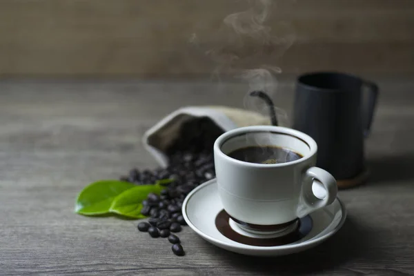 Kaffeezeit, frischer schwarzer Kaffee auf Holztisch, Kaffeebohnen in — Stockfoto