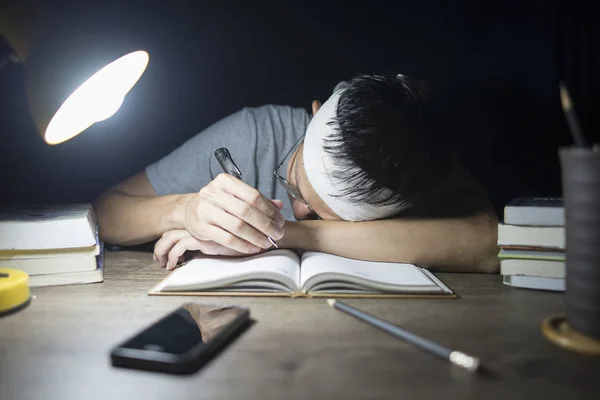 Chłopiec czyta książki przygotowujące do egzaminu, wydaje się być zmęczony — Zdjęcie stockowe