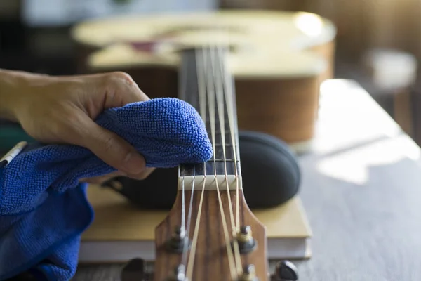 Gitar tamircisi akustik gitar temizliyor