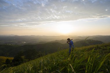 Yükselen güneş, sabahın erken saatlerinde tepenin manzarası