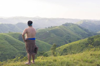 Doğanın ortasında dinlenen, tepenin üstünde duran bir adam..