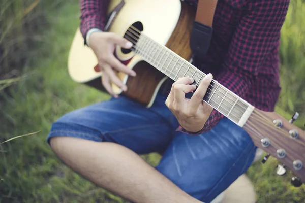 Music in nature, People playing guitar in lawn, Close-up
