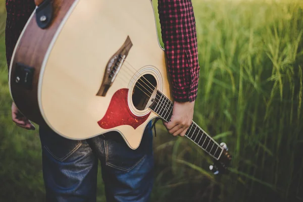 People wearing a plaid shirt, Holding an acoustic guitar on farm — Stock Photo, Image