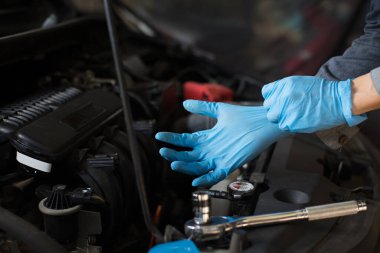 Araba bakımı, ayrılmadan önce motoru kontrol et, eldiven takan tamirci..