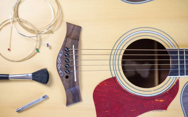 Gitara yerleştirilen akustik gitar bakımı, gitar telleri ve temizlik araçları, Top view.