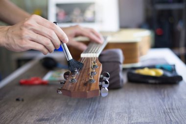 Akustik gitar bakımı, zanaatkar gitarı fırçayla temizliyor, kapat..