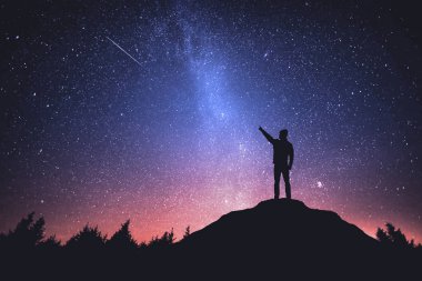 Gece gökyüzünde yıldızlar ve ayakta adam silüeti