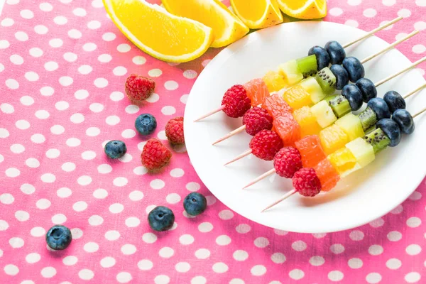 Frutos frescos em espetos em prato na mesa — Fotografia de Stock