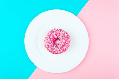 Minimalizm, mavi ve pembe arka plan üzerinde yukarıdan çörek fotoğrafta düz stil renk kontrastı