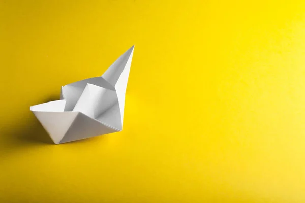 Origami de papel de barco no fundo amarelo — Fotografia de Stock