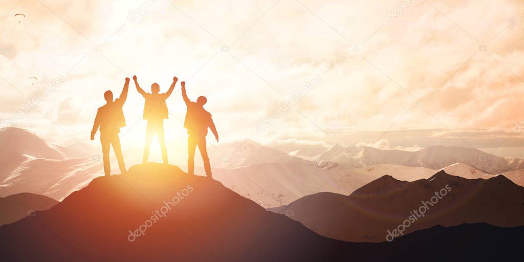 Silhouette of the team on the peak of mountain
