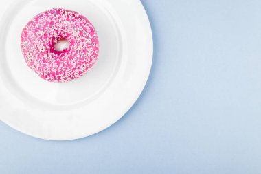 Pastel mavi zemin üzerine pembe sırlı çörek