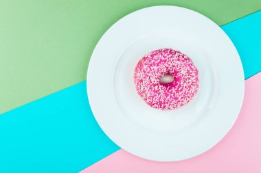 Renk arka plan üzerinde pembe sırlı çörek