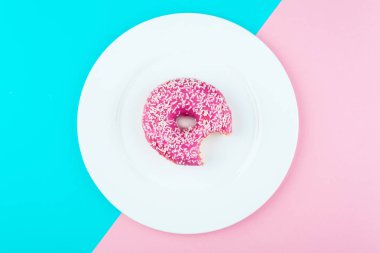 Minimalizm, mavi ve pembe arka plan üzerinde yukarıdan çörek fotoğrafta düz stil renk kontrastı