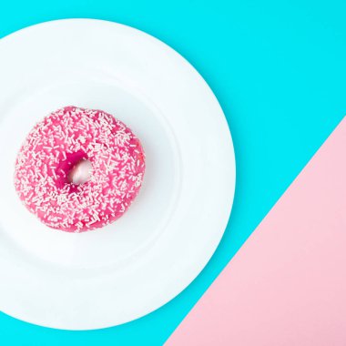 Minimalizm, mavi ve pembe arka plan üzerinde yukarıdan çörek fotoğrafta düz stil renk kontrastı