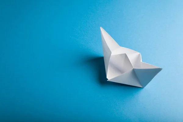 Kertas perahu origami pada latar belakang biru — Stok Foto