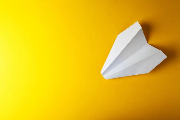 Бумажный самолет на ярко-желтом фоне — стоковое фото