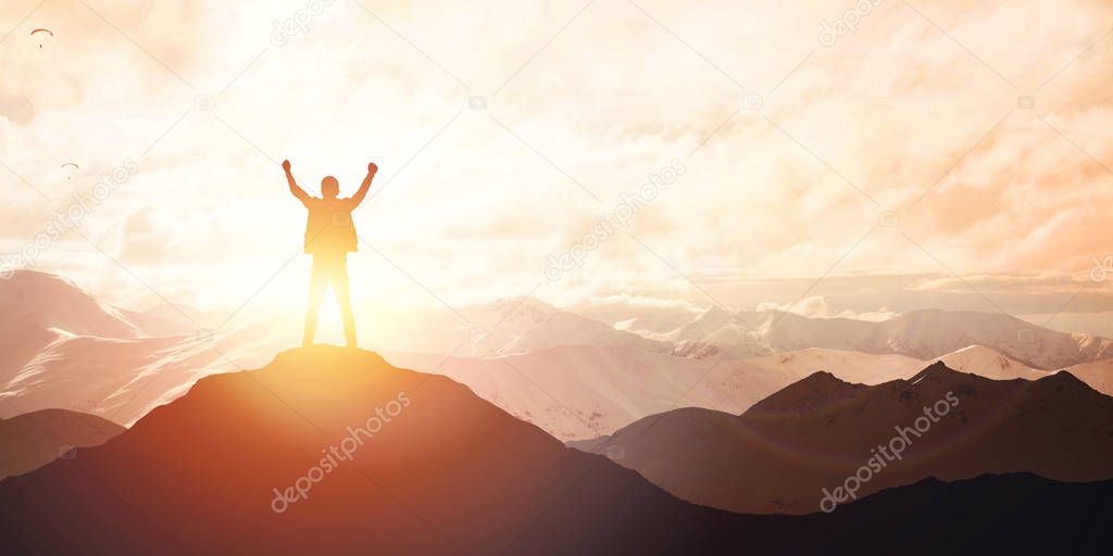 Silhouette of male on the peak of mountain