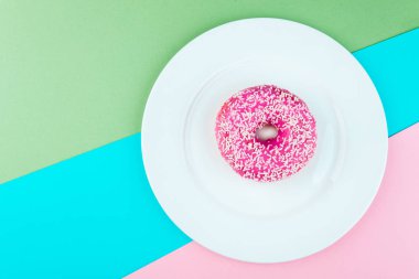 Renk arka plan üzerinde pembe sırlı çörek