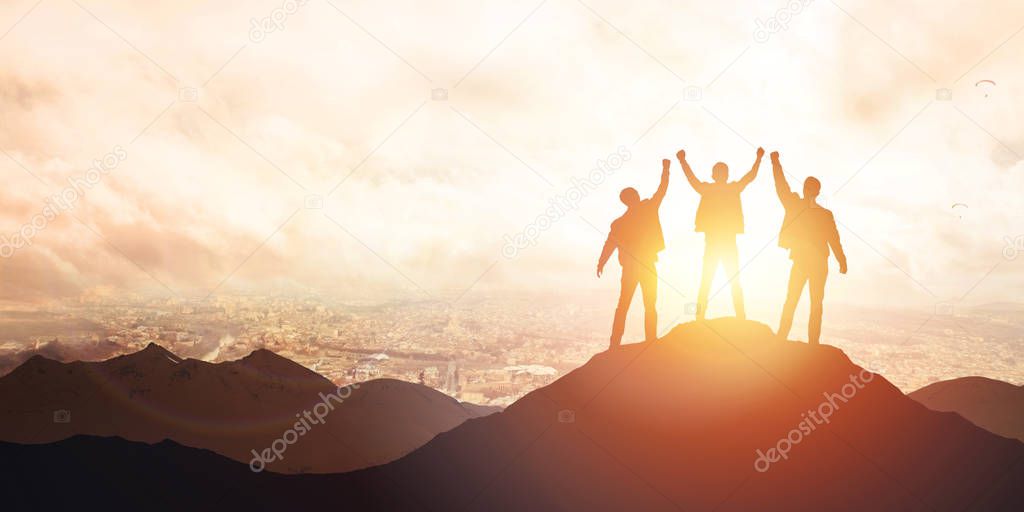 Silhouette of the team on the peak of mountain