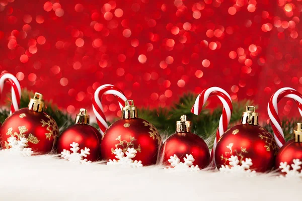 红色的圣诞球和糖果装饰红色背景 — 图库照片