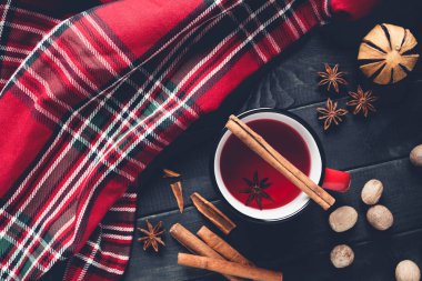 Noel mulled şarap ahşap arka plan üzerinde kırmızı mug içinde baharatlar ile.