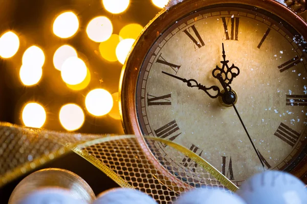 New Years clock and white balls covered with lights — Stock Photo, Image