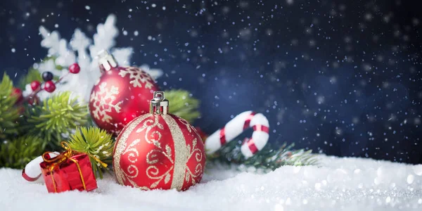 Bolas rojas de Navidad con decoraciones en la nieve —  Fotos de Stock