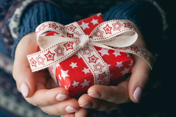 Primer plano de las manos femeninas sosteniendo un pequeño regalo — Foto de Stock