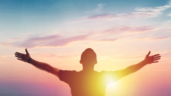 Young man standing outstretched at sunset. Victory — Stock Photo, Image