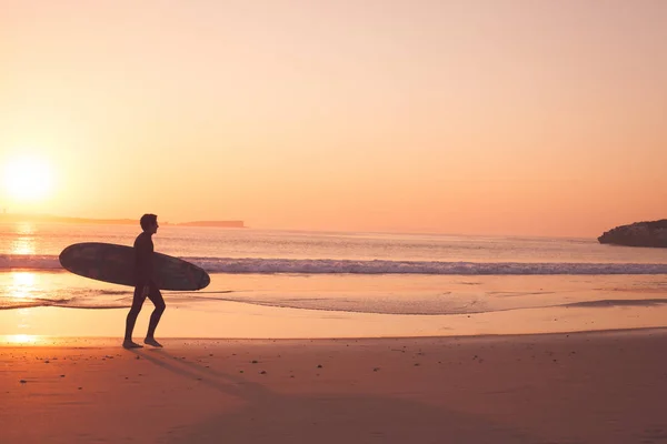 Peniche - Πορτογαλία - 26 Σεπτεμβρίου 2018 - Surfer που τρέχει στην παραλία με την Ανατολή — Φωτογραφία Αρχείου