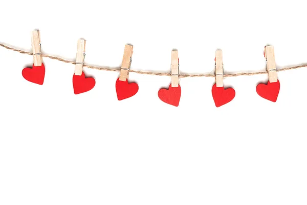 Kleding haringen en rood papier harten op touw geïsoleerd op witte achtergrond — Stockfoto