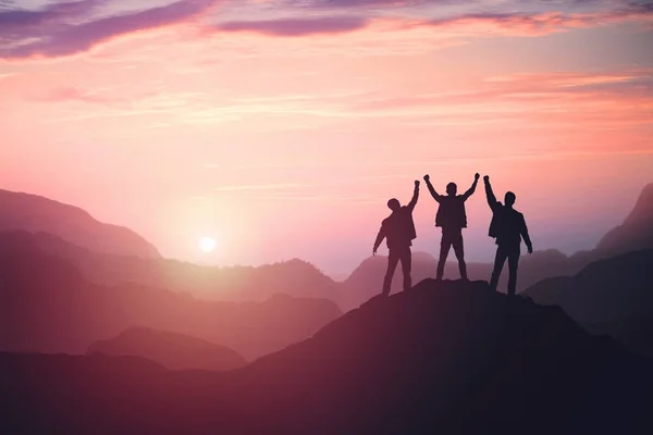 Three guys celebrating victory on top of a mountain — Stock Photo, Image