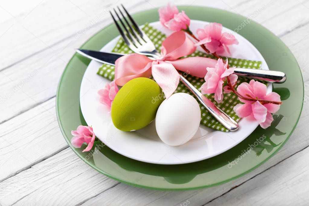 Easter table setting with spring flowers and cutlery.