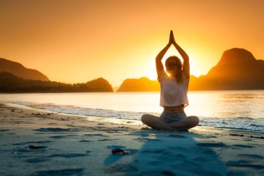 Kadın yoga yapıyor ve dağda meditasyon yapıyor..