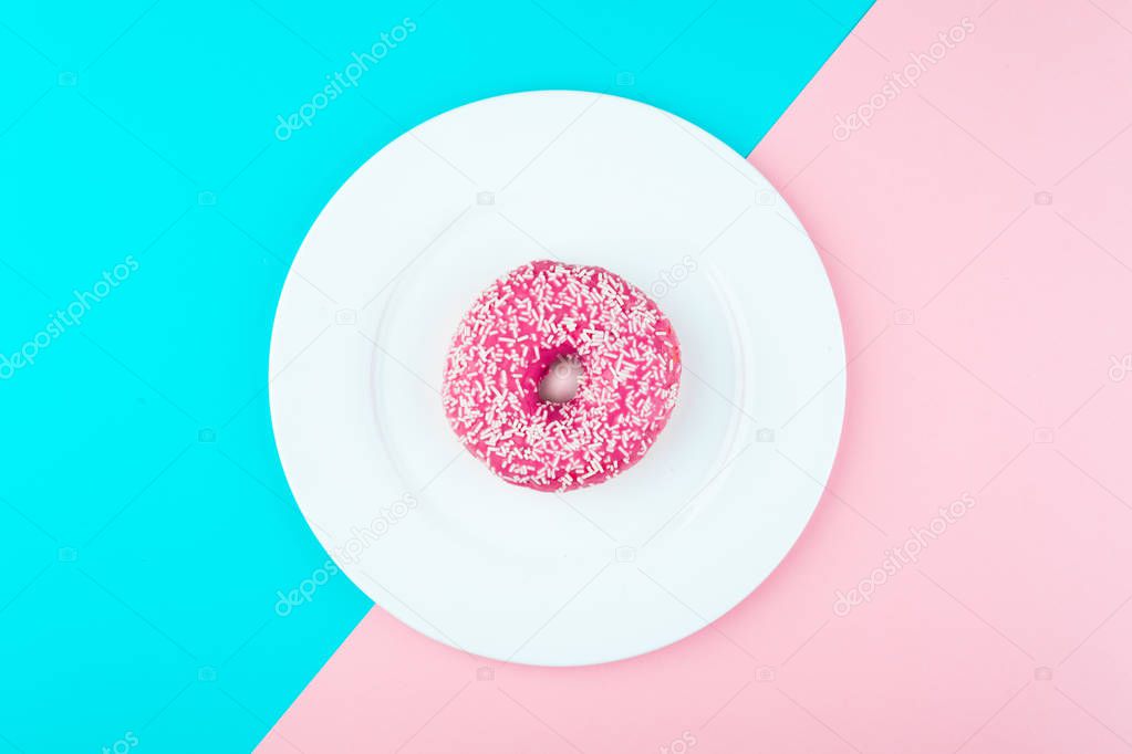 Donut covered with icing in plate, top view