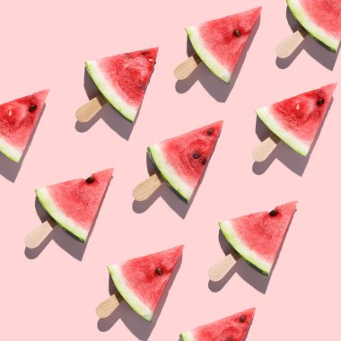 Pembe bir arka plan üzerinde düzenlenen karpuz dilimli