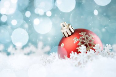 Soyut mavi arkaplanda kar taneleri olan Noel balosu.