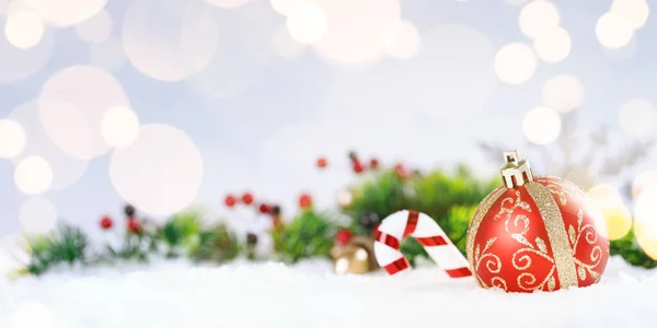 Boże Narodzenie czerwona piłka z cukierkami i dekoracji na śniegu. — Zdjęcie stockowe