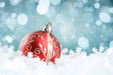 Soyut mavi arkaplanda kar taneleri olan Noel balosu.