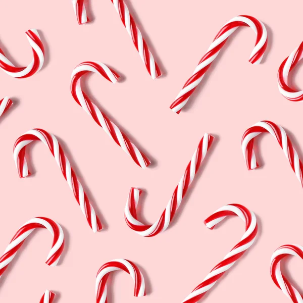 Vlakke lay compositie met snoepstokken op roze achtergrond. — Stockfoto