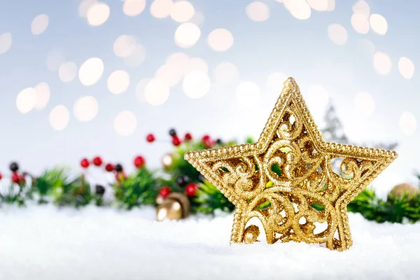 Estrella de oro de Navidad en la nieve con decoración . —  Fotos de Stock